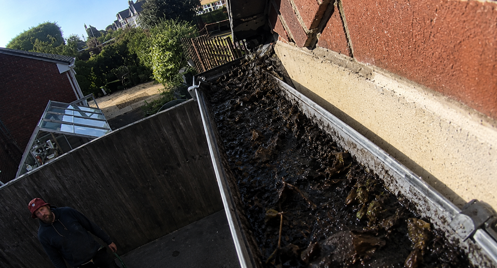 Before gutter cleaning — summer debris accumulation visible in Birmingham property